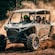 2 Guests in helmets taking a drive in a dune buggy amid swirls of dust at Kuza Beach Park